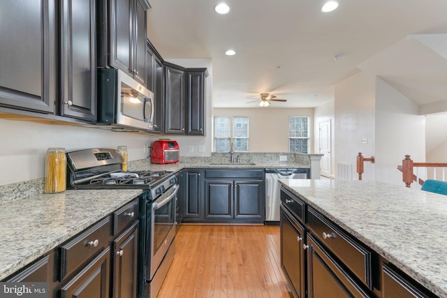 kitchen with sink, light stone counters, and stainless steel appliances