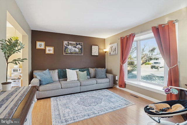 living room featuring a healthy amount of sunlight and light hardwood / wood-style flooring