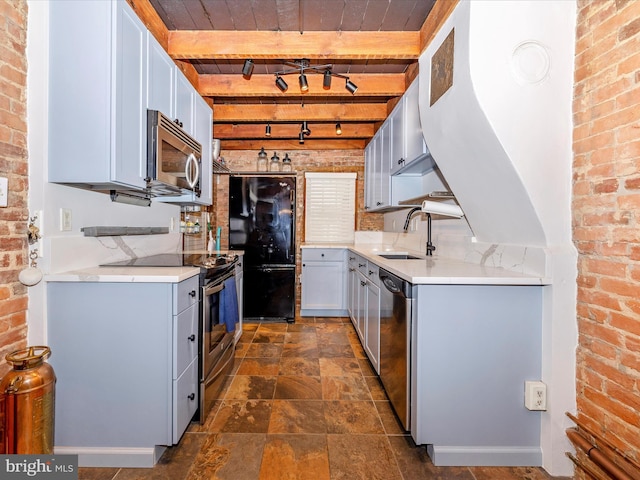 kitchen with sink, beamed ceiling, brick wall, wood ceiling, and appliances with stainless steel finishes