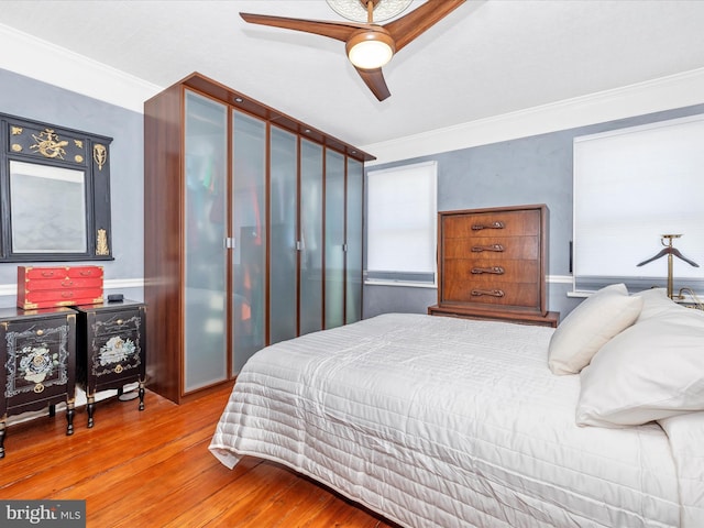 bedroom with ornamental molding, light wood-type flooring, and ceiling fan