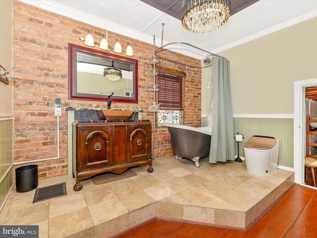 bathroom with brick wall, separate shower and tub, crown molding, and vanity