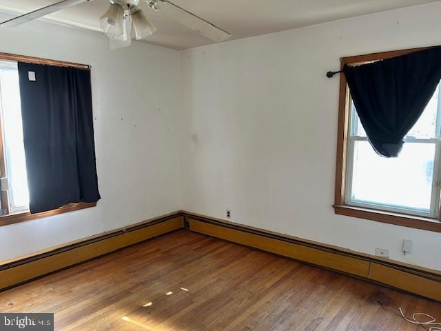 spare room featuring a baseboard radiator and hardwood / wood-style floors