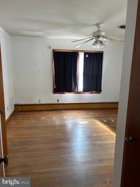 unfurnished room with hardwood / wood-style flooring and ceiling fan