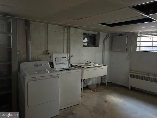 clothes washing area with separate washer and dryer and radiator