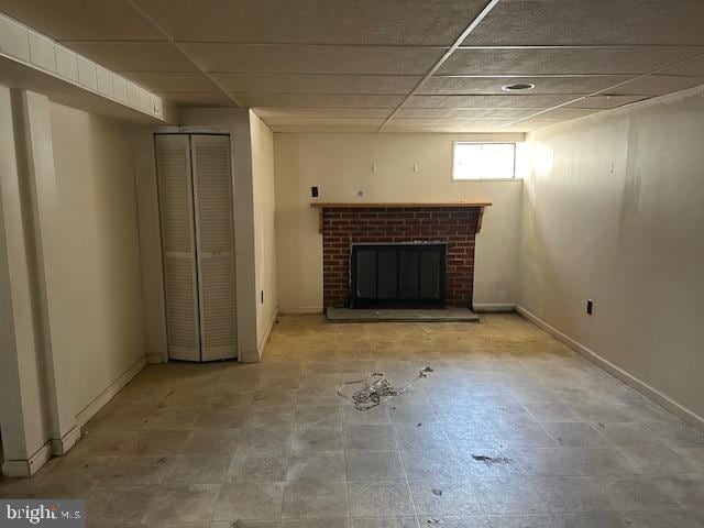 unfurnished living room featuring a paneled ceiling and a fireplace