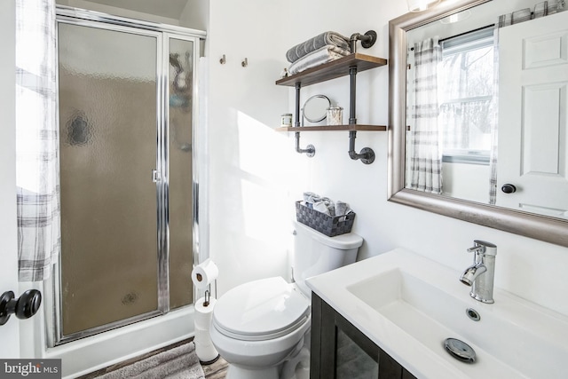 bathroom featuring an enclosed shower, vanity, and toilet