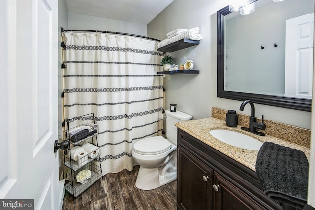 bathroom featuring toilet, vanity, and hardwood / wood-style floors