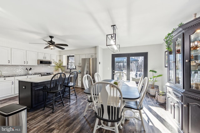 dining space featuring dark wood-type flooring, ceiling fan, and sink