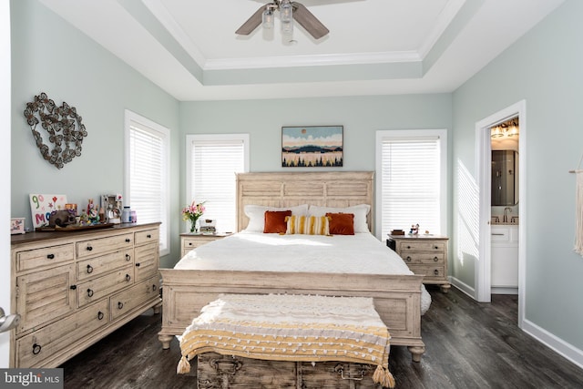 bedroom featuring ensuite bath, ceiling fan, dark hardwood / wood-style floors, and a tray ceiling