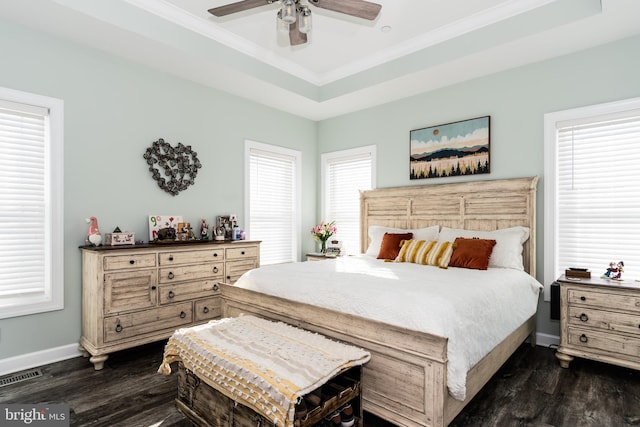 bedroom with a tray ceiling, dark hardwood / wood-style floors, crown molding, and ceiling fan