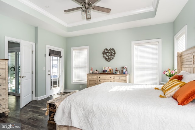 bedroom featuring dark hardwood / wood-style floors, ceiling fan, access to exterior, and a raised ceiling