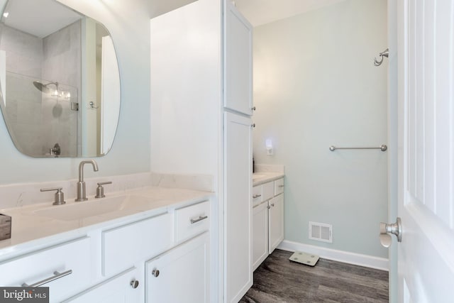 bathroom featuring walk in shower, vanity, and hardwood / wood-style flooring