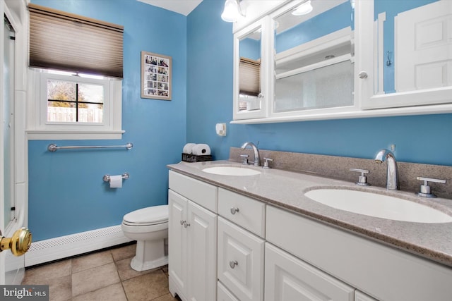 bathroom featuring baseboard heating, vanity, toilet, and tile patterned flooring