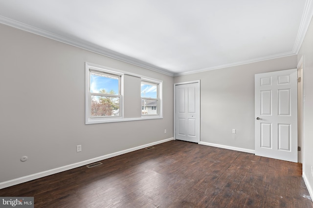 spare room featuring crown molding and dark wood-type flooring