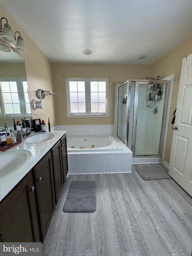 bathroom with hardwood / wood-style floors, vanity, and shower with separate bathtub