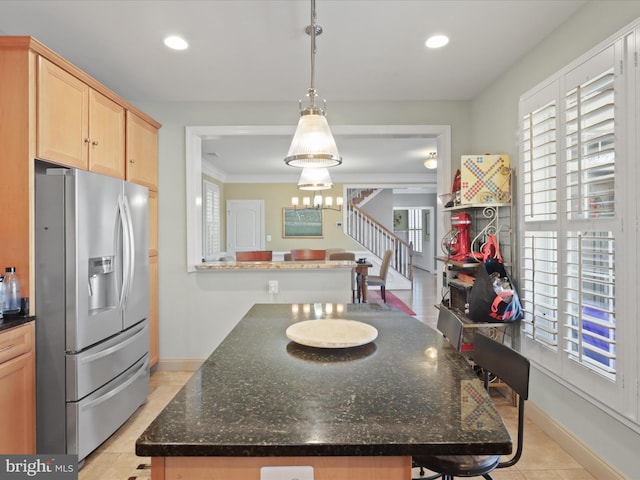 kitchen featuring light tile patterned floors, light brown cabinetry, a kitchen island, stainless steel refrigerator with ice dispenser, and decorative light fixtures