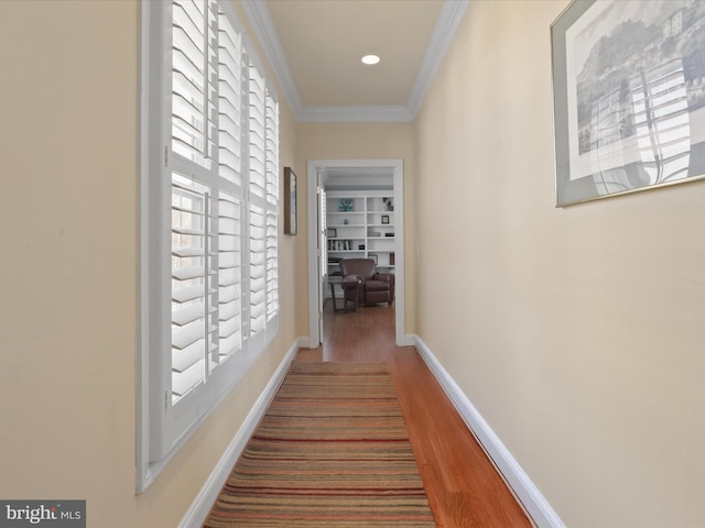 hall with crown molding, hardwood / wood-style flooring, and built in features