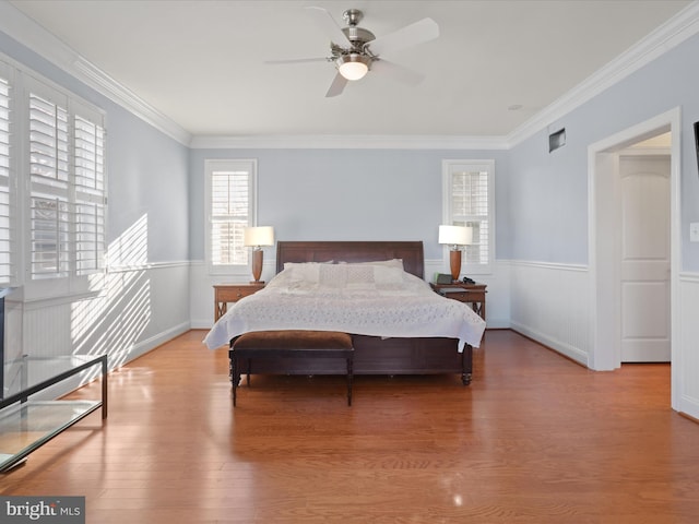 bedroom with ceiling fan, crown molding, and light hardwood / wood-style flooring