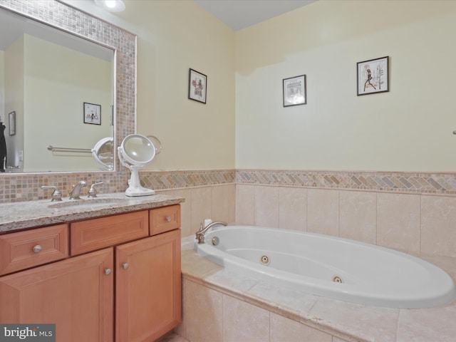 bathroom featuring vanity and tiled tub