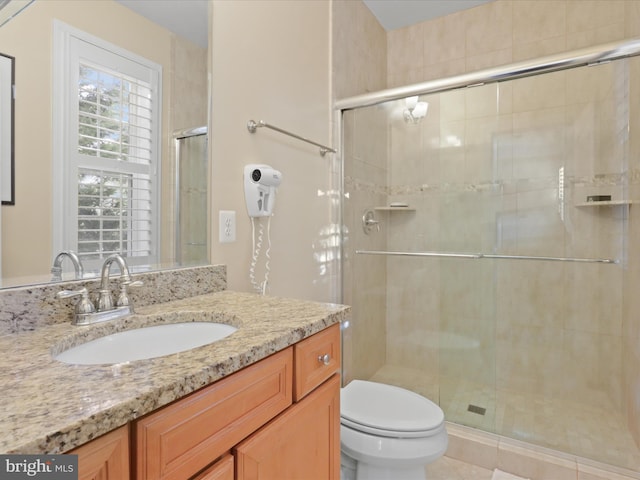 bathroom with walk in shower, vanity, and toilet