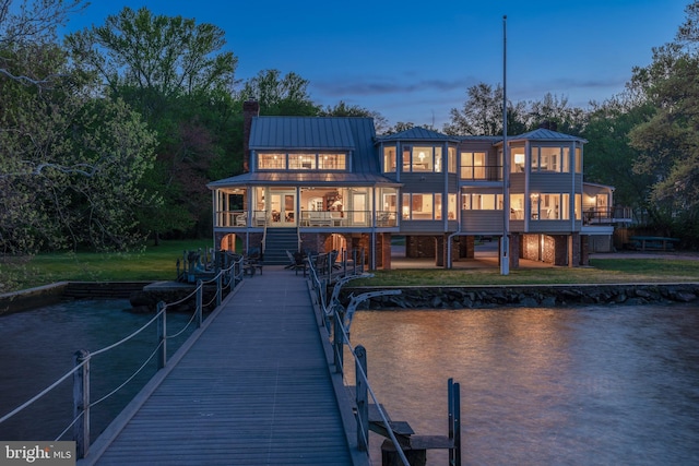 back house at dusk featuring a balcony