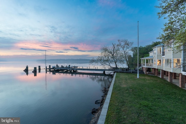 dock area featuring a water view and a lawn