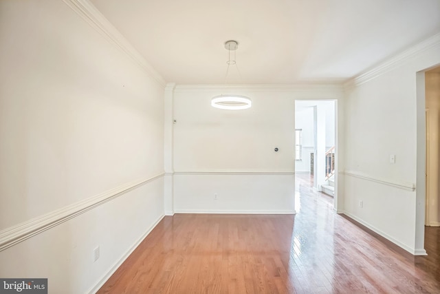 unfurnished room featuring hardwood / wood-style floors and ornamental molding