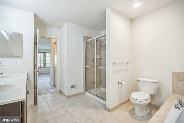 bathroom featuring tile patterned floors, vanity, a shower with shower door, and toilet