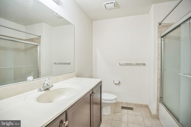 full bathroom with tile patterned flooring, vanity, bath / shower combo with glass door, and toilet