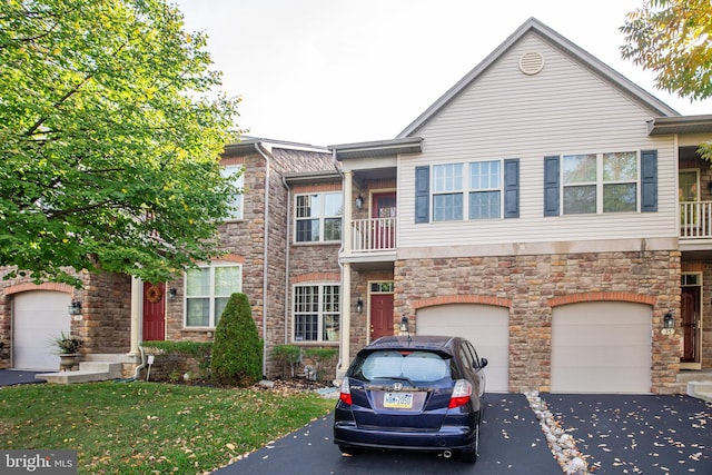 townhome / multi-family property with a garage and a front yard