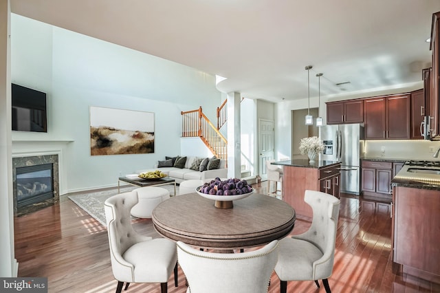 dining space featuring dark hardwood / wood-style flooring, sink, and a high end fireplace