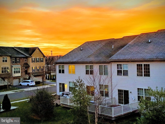 back house at dusk with a deck