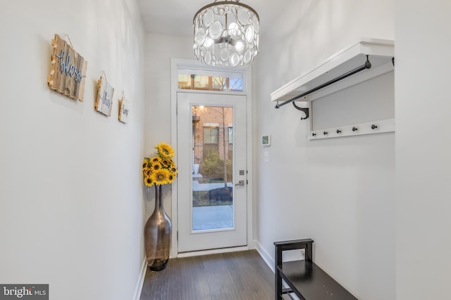 doorway featuring baseboards, a notable chandelier, and dark wood-style flooring