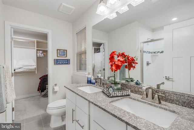 full bathroom featuring tile patterned flooring, a stall shower, toilet, and a sink