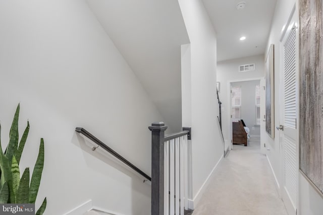 corridor featuring visible vents, baseboards, light colored carpet, an upstairs landing, and recessed lighting