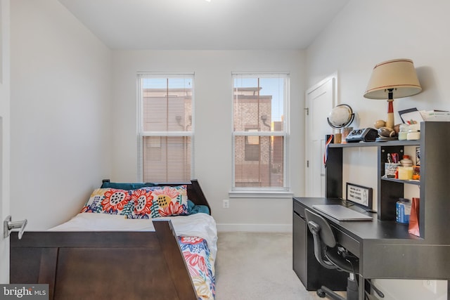 bedroom with light colored carpet and baseboards