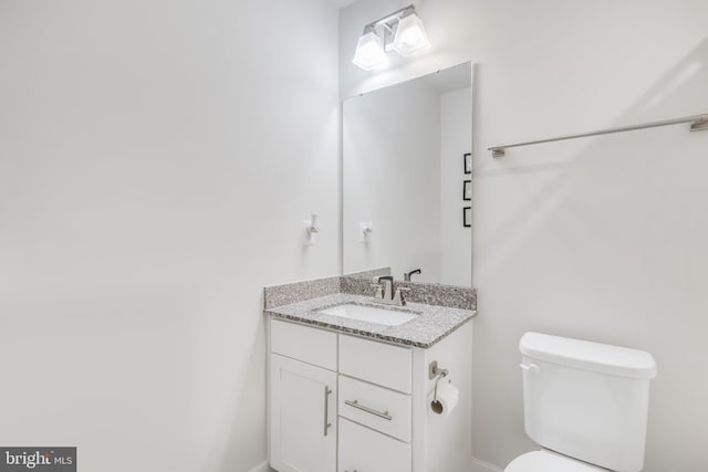 half bath featuring toilet and vanity