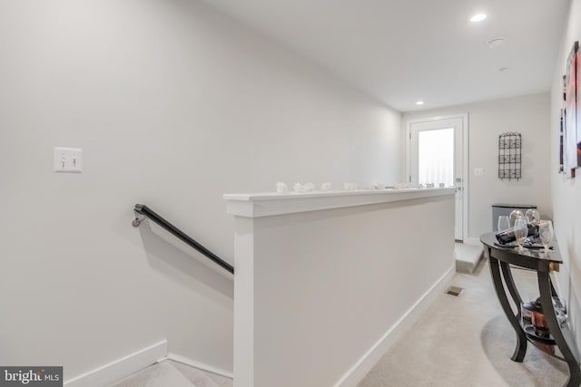 hall featuring visible vents, an upstairs landing, light carpet, recessed lighting, and baseboards