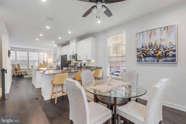 dining room with recessed lighting, a healthy amount of sunlight, dark wood-style flooring, and baseboards