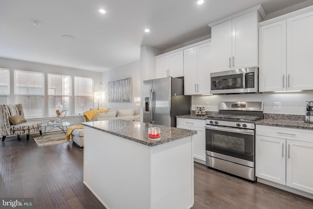 kitchen featuring dark wood finished floors, white cabinetry, appliances with stainless steel finishes, and a kitchen island