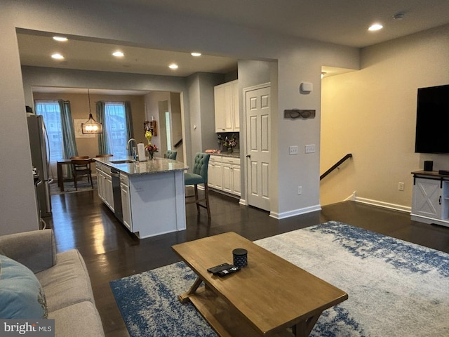 living room featuring sink and dark hardwood / wood-style floors