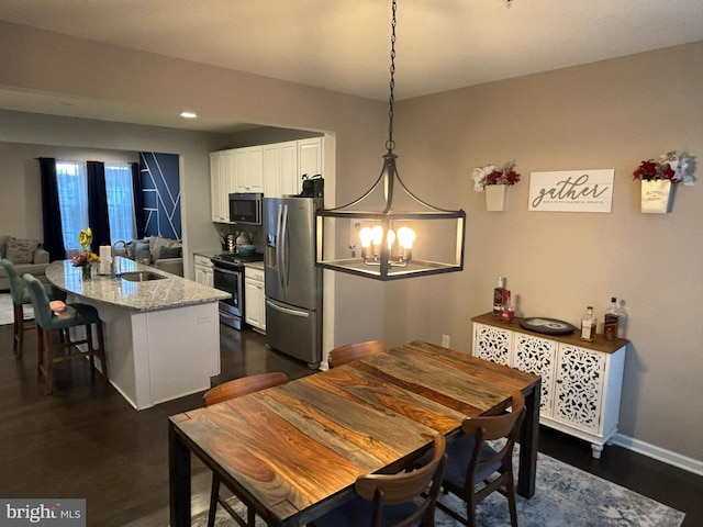 dining room with a notable chandelier, dark hardwood / wood-style floors, and sink