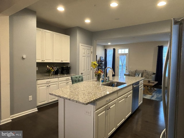 kitchen featuring sink, a center island with sink, white cabinetry, and appliances with stainless steel finishes