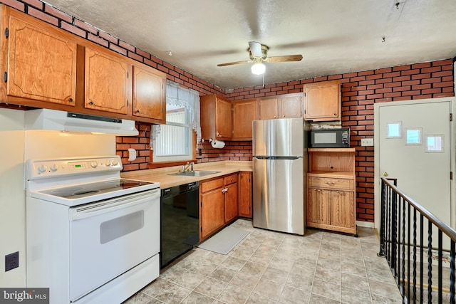 kitchen with ceiling fan, black appliances, sink, a textured ceiling, and brick wall