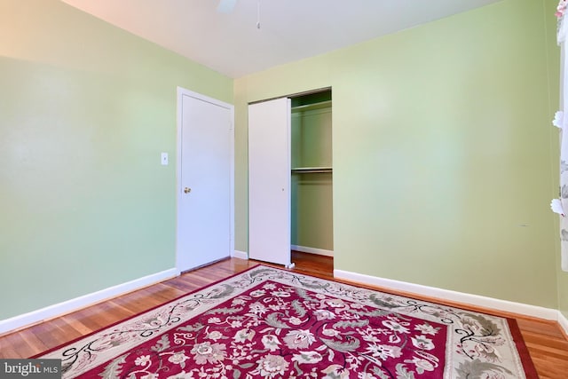 bedroom with ceiling fan, a closet, and hardwood / wood-style floors