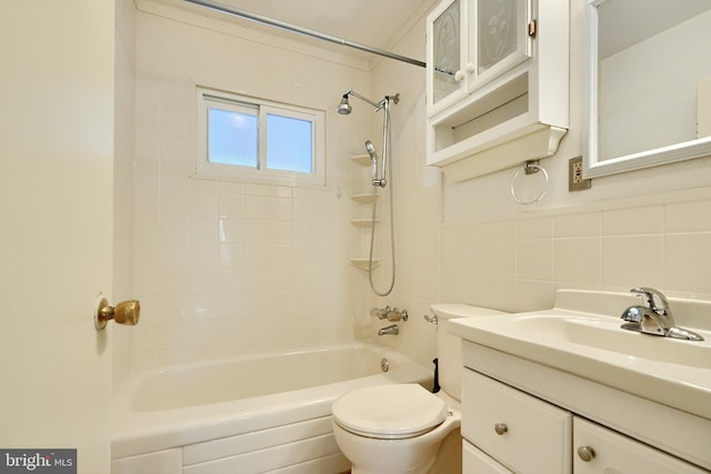 full bathroom with tiled shower / bath, vanity, tasteful backsplash, tile walls, and toilet