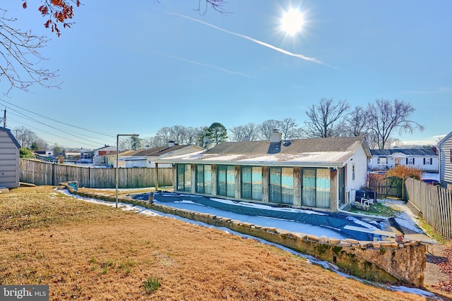 rear view of house with a yard and a sunroom