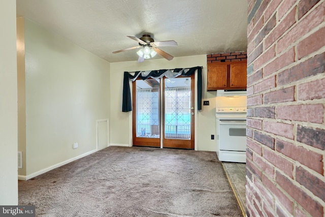 kitchen featuring carpet floors, ceiling fan, white electric stove, a textured ceiling, and brick wall