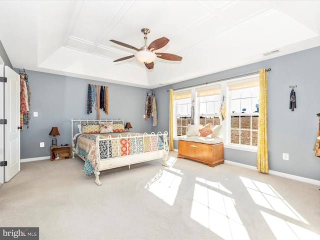 carpeted bedroom featuring a raised ceiling and ceiling fan