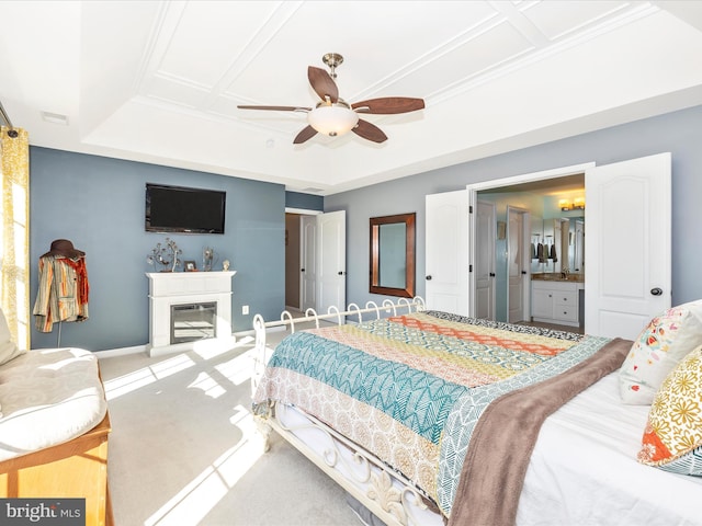 carpeted bedroom with coffered ceiling, connected bathroom, a tray ceiling, and ceiling fan